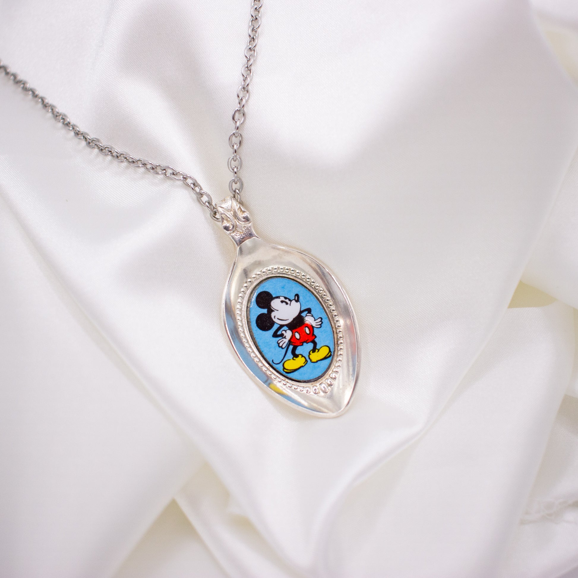 mickey mouse necklace with mickey against a blue background 