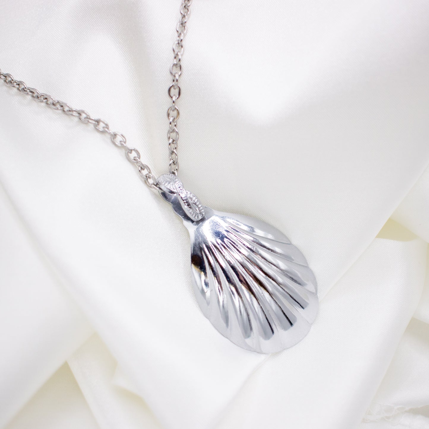 the back of a spoon necklace against a white background