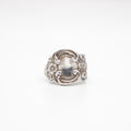 Silver ring with intricate design on a white background